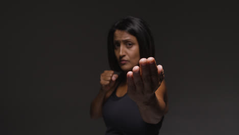 Studio-Portrait-Of-Mature-Woman-Wearing-Gym-Fitness-Clothing-Exercising-Sparring-At-Camera-1